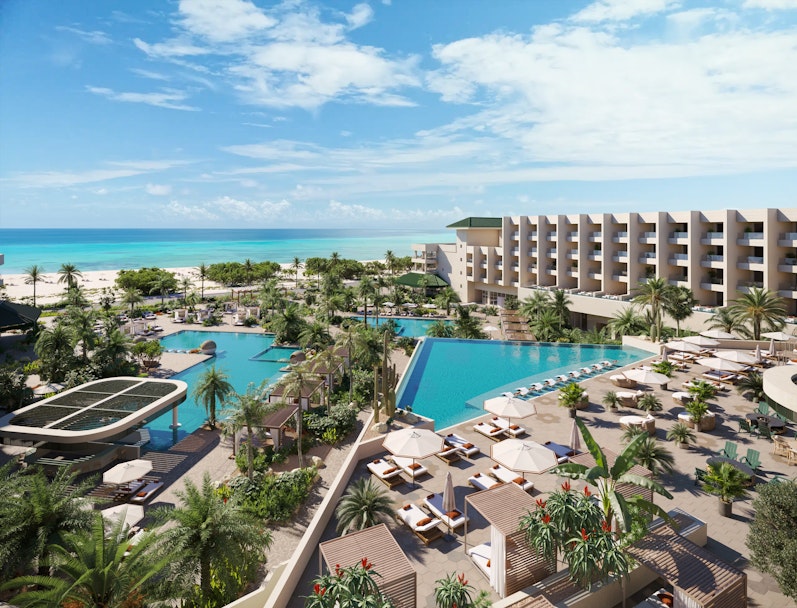 Resort met infinity pool, palmbomen en uitzicht op zee